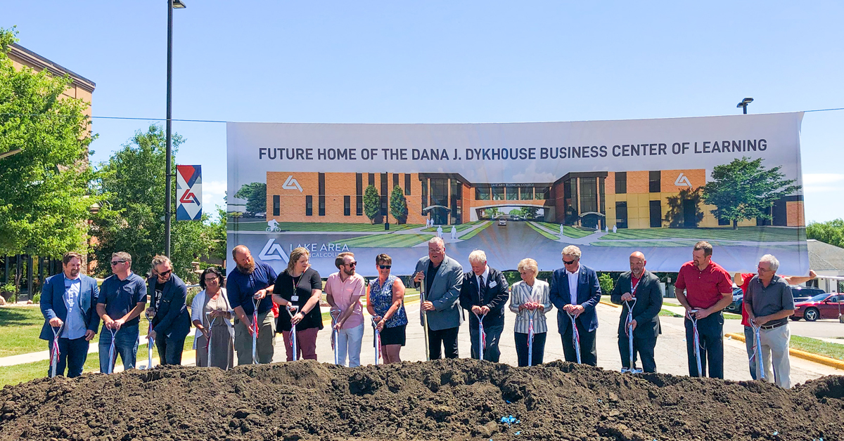 Group of people with shovels lined up for a groundbreaking ceremony